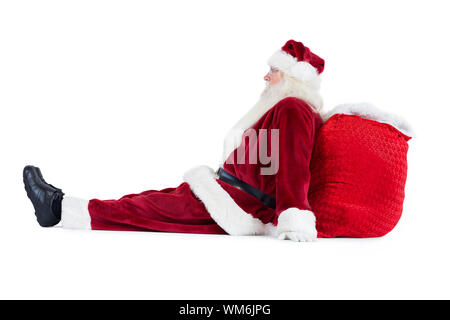 Santa sitzt auf seinem Beutel auf weißem Hintergrund lehnte Stockfoto