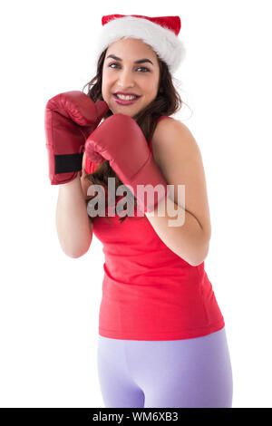 Festliche Brünette in Boxhandschuhen auf weißem Hintergrund Stockfoto