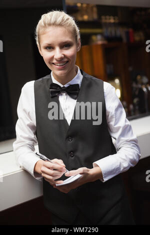 Hübsche Kellnerin nehmen einen Auftrag in eine Bar Stockfoto