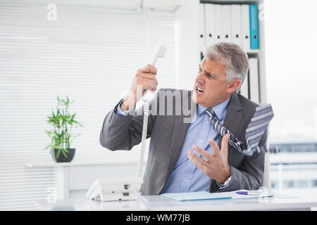 Wütend Geschäftsmann schreien auf das Telefon in seinem Büro Stockfoto