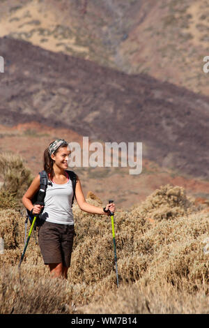 Frau wandern. Junge asiatische Frau Modell gehen mit Wanderstöcken/Walking Stöcke während einer Wanderung/Rucksacktour in der wunderschönen und wilden vulkanischen Stockfoto