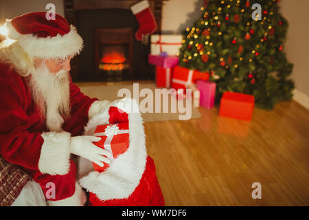 Santa claus stocking Geschenke an Weihnachten zu Hause im Wohnzimmer Stockfoto