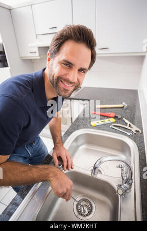 Klempner zur Festsetzung Waschbecken mit einem Schraubendreher in die Küche Stockfoto