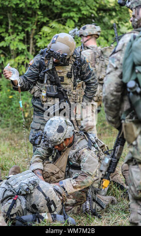 Ein Soldat von C Troop, 1st Squadron, 75th Cavalry Regiment, 2nd Brigade Combat Team bietet erste Hilfe zu simulierten Unfall bei einer gemeinsamen Übung in Fort Campbell, Mittwoch, 16. August 2019. Die Soldaten verbrachten zwei Wochen Training mit grünen Barette aus dem 5 Special Forces Group (Airborne), auf Schlacht Bohrer, Umgang mit Kriegsgefangenen, taktische Unfallversicherung Versorgung und Evakuierung und Missionsplanung. (U.S. Armee Foto: Staff Sgt. Iman Broady-Chin) Stockfoto