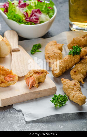 Lachs in Kräuter-Teig mit würzigen Dressing - Fish &amp; Chips ohne Fett chips mit gemischtem Salat mit Endivien und tschechisches Bier Stockfoto