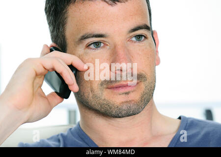 entspannter Mann mit einer Kommunikation mit einem cellephone Stockfoto