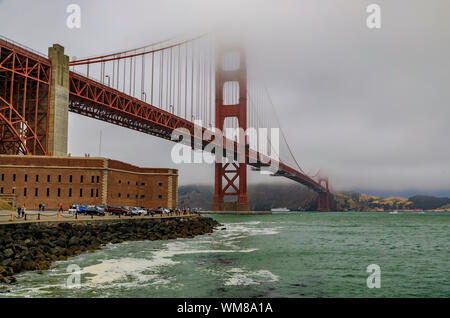 Die berühmte Golden Gate Bridge an einem bewölkten Sommertag mit niedrig hängenden Nebel rollen in San Francisco, Kalifornien Stockfoto