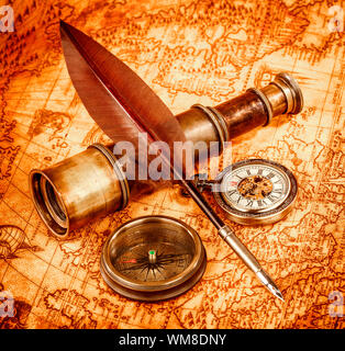 Vintage Lupe, Kompass, Gans Federkiel und Spyglass liegend auf einer alten Karte im Jahre 1565. Stockfoto