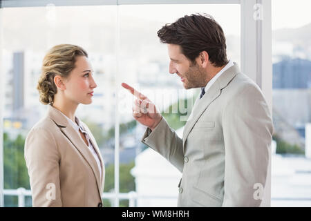 Zornigen Mann bei seinen Kollegen im Büro zeigen Stockfoto