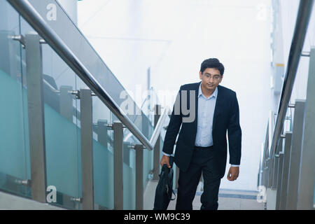 Asiatische indische corporate Geschäftsmann im Anzug mit Aktentasche aufsteigender Schritte. Stockfoto