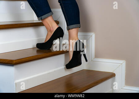 Mädchen mit Heels und jeand auf der Treppe hinauf Stockfoto