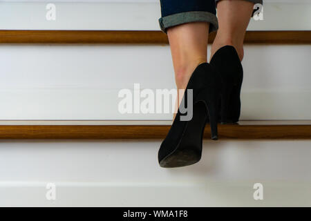 Mädchen mit Heels und jeand auf der Treppe hinauf Stockfoto