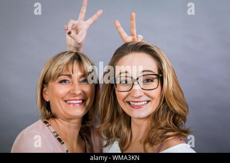 Lächelnd im mittleren Alter junge Mutter und Tochter Stockfoto