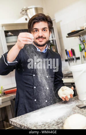 Professionelle Köchin oder Koch in einer Großküche warf Teig bei der Herstellung von Gebäck für Desserts im Restaurant oder im hotel Stockfoto