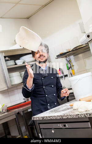 Professionelle Köchin oder Koch in einer Großküche warf Teig bei der Herstellung von Gebäck für Desserts im Restaurant oder im hotel Stockfoto