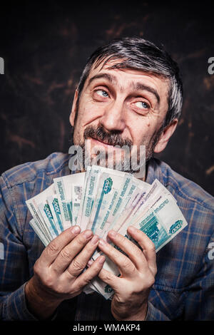 Mann Geld in seinen Händen halten Stockfoto