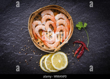 Frische Garnelen auf Bambus Dampfer mit Gewürzen lemon Chili auf der dunklen Platte/gekochte geschälte Garnelen Garnelen im Seafood Restaurant zubereitet Stockfoto