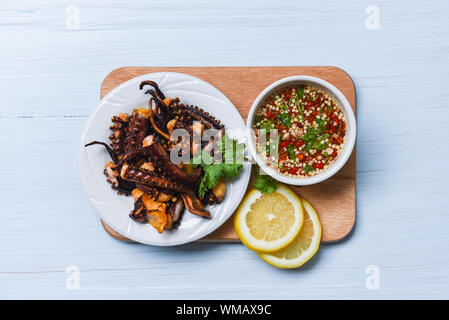 Oktopus Salat mit Zitrone Kräuter und Gewürze auf weiße Platte/Tentakel Tintenfisch gegrillt Vorspeise essen heiß und würzig Chili Sauce gekocht serviert Meeresfrüchte Stockfoto