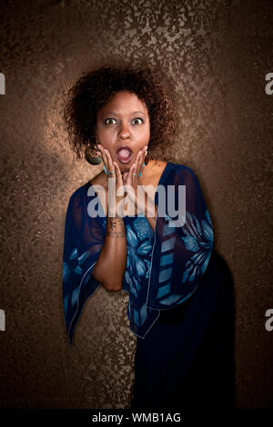 Ziemlich Afroamerikanerfrau blauen Kleid gefangen im Rampenlicht Stockfoto