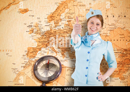 Hübsche Stewardess mit Hand auf der Hüfte gegen Weltkarte mit Kompass, Europa und im Nahen Osten Stockfoto