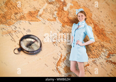 Hübsche Stewardess mit Hand auf der Hüfte gegen Weltkarte mit Kompass zeigt im südlichen Asien Stockfoto