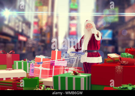Santa mit Geschenken von Karre gegen New Yorker Straße verschwommen Stockfoto