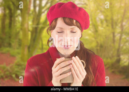 Frau mit einer warmen Tasse gegen friedliche Herbst Szene im Wald Stockfoto