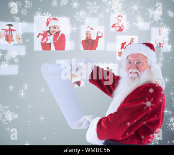Der Weihnachtsmann hält eine Liste gegen Grau Vignette Stockfoto