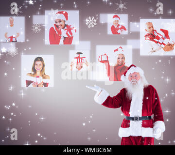 Santa zeigt etwas auf die Kamera gegen Grau Vignette Stockfoto