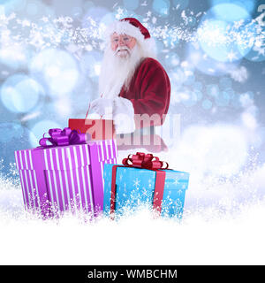Santa trägt rot Geschenkbeutel gegen Licht leuchtenden Punkte Design Pattern. Stockfoto