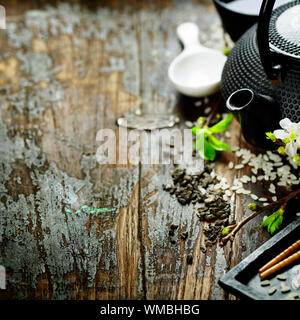 Chinesische Tee-Set, Stäbchen und Sakura Zweig am rustikalen Holztisch Stockfoto