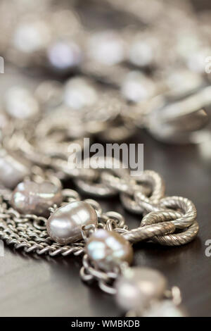 Sortierte silber Modeschmuck mit einem verworrenen Haufen von Ketten mit unterschiedlich geformte links, eine Klare Kristallperlen und eine Kette von runden Silber Perlen Stockfoto
