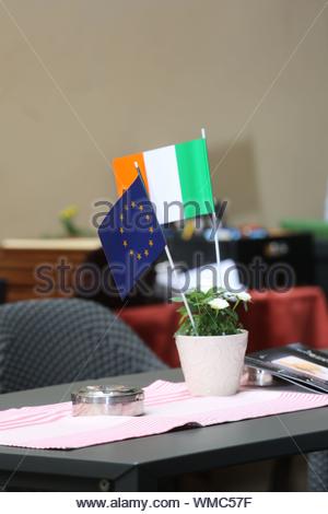 Die EU und die irische Flagge stehen nebeneinander auf einem Tisch während Präsident Michael D Higgins' Besuch in Würzburg in Deutschland. Stockfoto