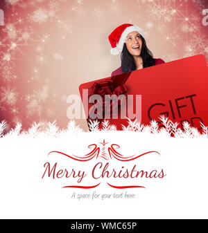 Das zusammengesetzte Bild der Frau mit einem weißen Schild gegen Grenze Stockfoto