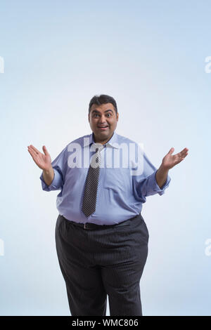 Portrait von lächelnden beleibten Mann in formelle Kleidung stehen mit offenen Handflächen auf Seiten Stockfoto