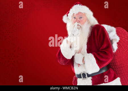 Santa bitten um ruhig mit Tasche gegen roter Hintergrund Stockfoto