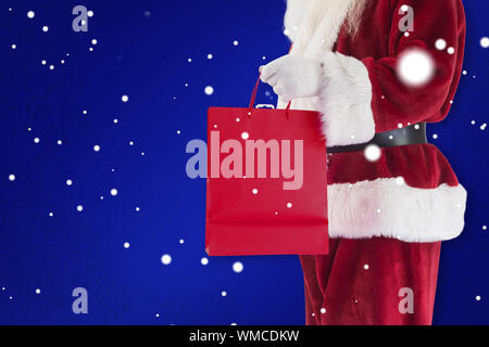 Santa trägt rot Geschenkbeutel gegen Blau Stockfoto