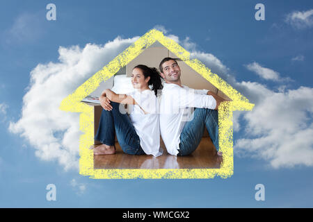 Strahlende Paar mit Auspacken der Kartons Umzug in ein neues Haus gegen bewölkter Himmel Stockfoto