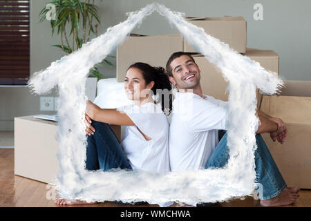 Hell Paar mit Auspacken der Kartons Umzug in ein neues Haus gegen Haus in Wolken Stockfoto