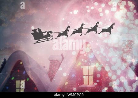 Silhouette der Weihnachtsmann und Rentier gegen niedlichen Christmas Village Stockfoto