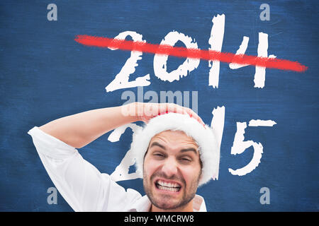 Festliche Mann hält Weihnachtsgeschenke gegen blaue Tafel Stockfoto