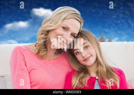 Mutter und Tochter gegen das zusammengesetzte Bild von Tannen in verschneiter Landschaft Stockfoto