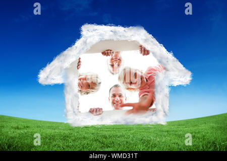 Glückliche Familie auspacken Boxen gegen grüne Feld unter blauem Himmel Stockfoto