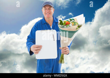 Happy Flower Delivery Man, die Zwischenablage gegen den blauen Himmel mit Wolken Stockfoto