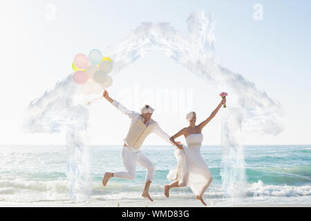 Haus in Wolken gegen die Jungvermählten Spaß holding Ballons Stockfoto