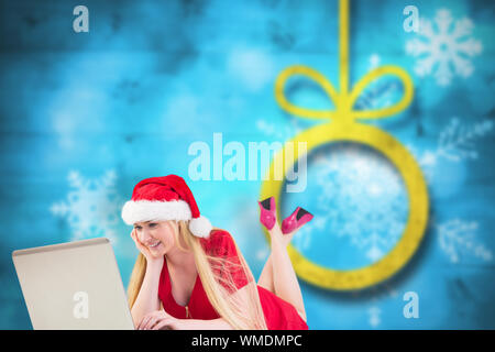 Festliche Blondine mit einem Laptop gegen Weihnachten Hintergrund verschwommen Stockfoto