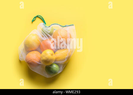 Obst und Gemüse in wiederverwendbare Umweltfreundliche mesh Taschen auf gelben Hintergrund. Null Abfall einkaufen. Ökologische Konzept. Stop Umweltverschmutzung. Stockfoto