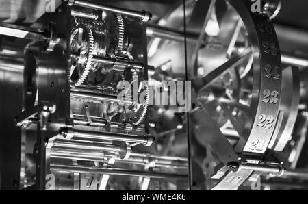 Mechanismus der alten Uhr, Fragment mit glänzenden Zahnrädern und Kalendertagen Zähler. Schwarz und Weiß, retro style Foto Stockfoto