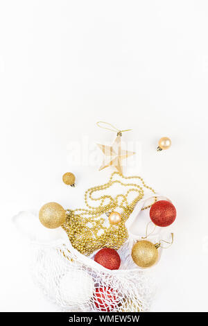 Weihnachten Komposition. Silvester oder Weihnachten flach Draufsicht Xmas holiday Dekorative golden Toys im eco-friendly shopping Netzbeutel auf weißem backgrou Stockfoto