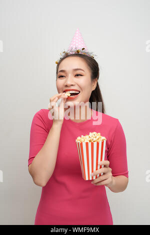 Portrait von eine lachende Frau mit Popcorn auf weißem Hintergrund Stockfoto